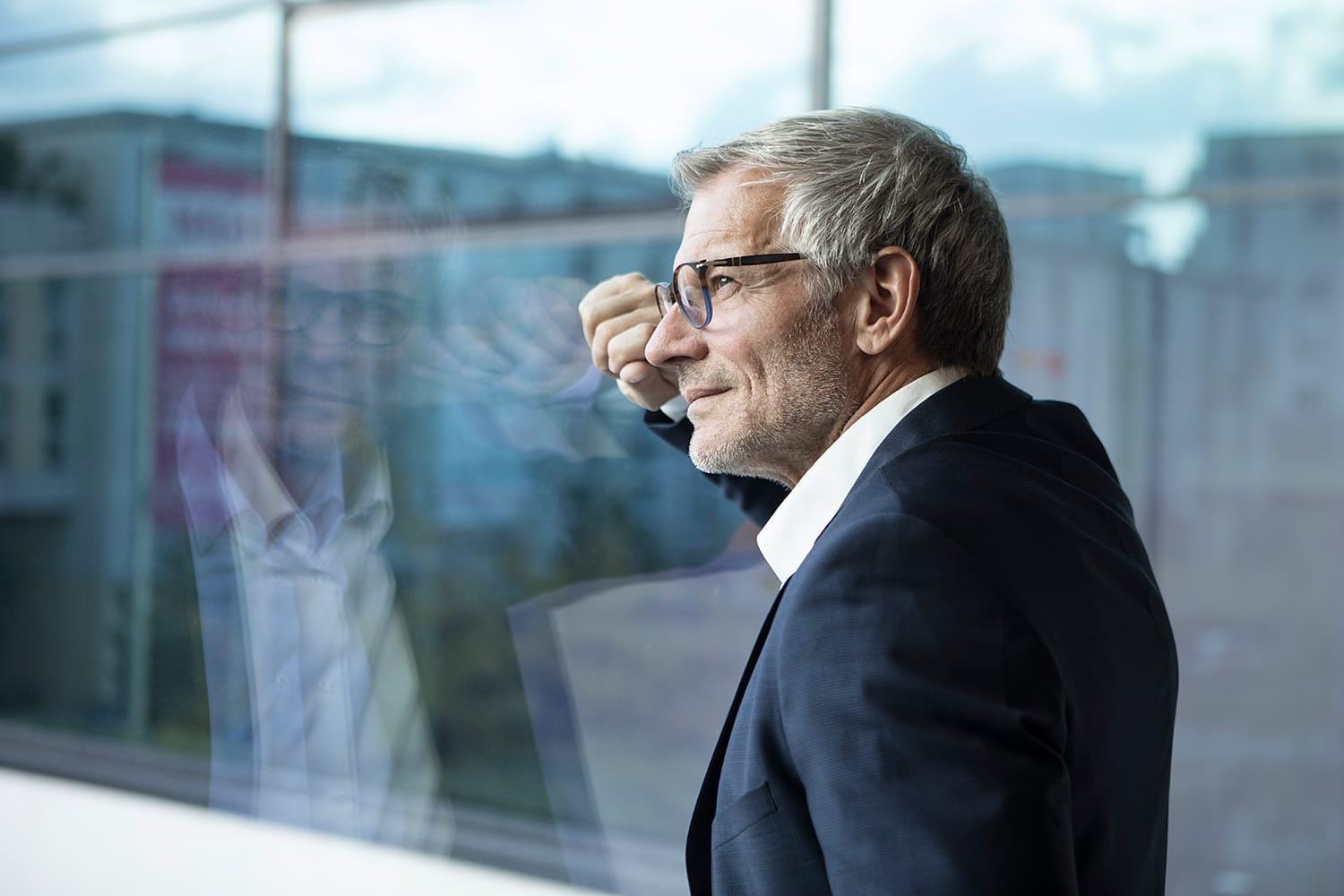Confident businessman looking out of window Confident businessman looking out of window