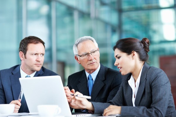 three business people discussing presentation three business people discussing presentation