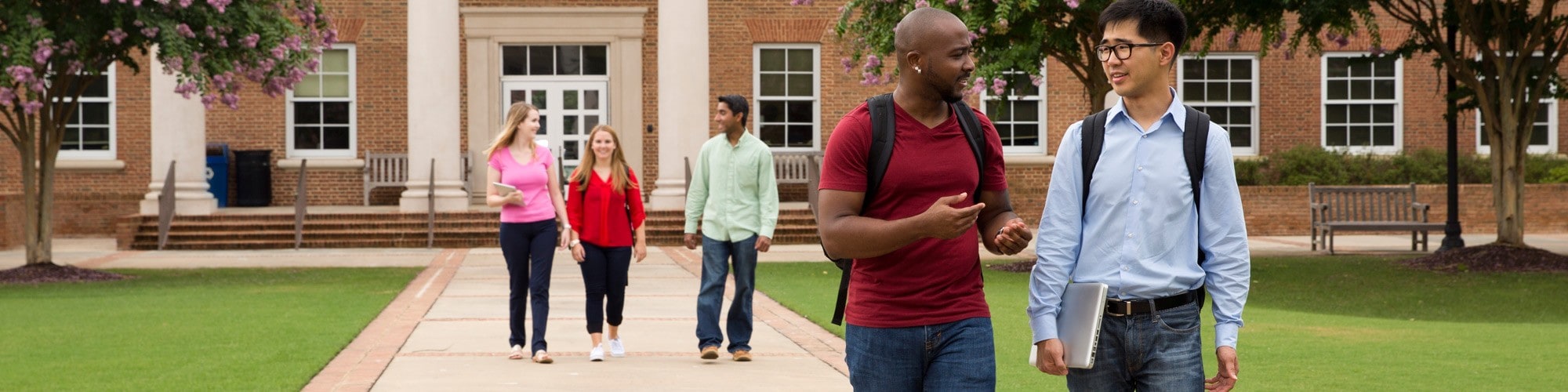 Five students walking in discussion on Cary Academy campus