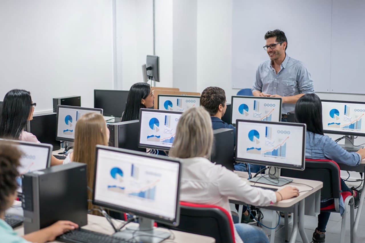 Teacher giving an IT class at school Teacher giving an IT class at school