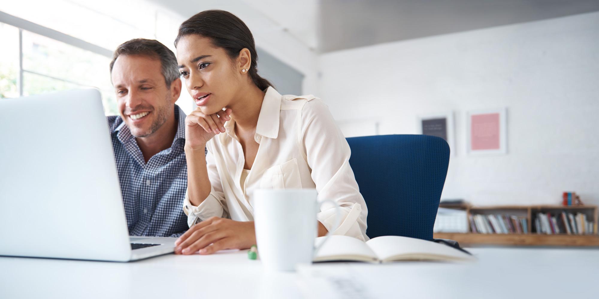 Two people looking at a laptop