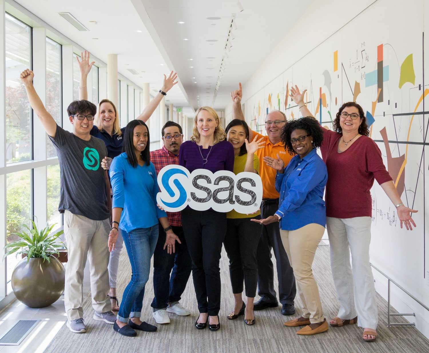 SAS employees holding SAS sign in hallway