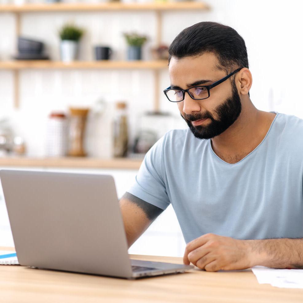 Man sitting at a desk looking at laptop