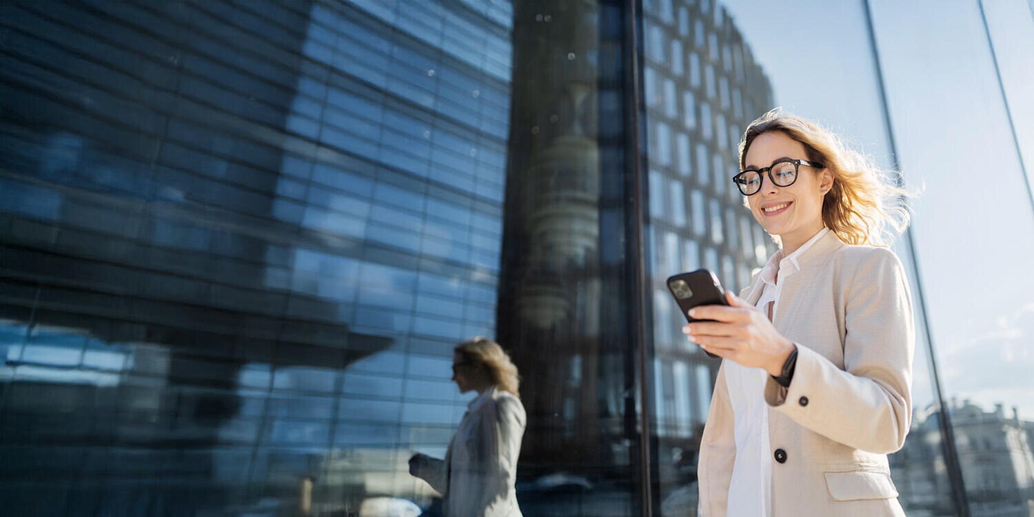 Captive Finance for Telecom and Media Technology Woman with glasses using her phone