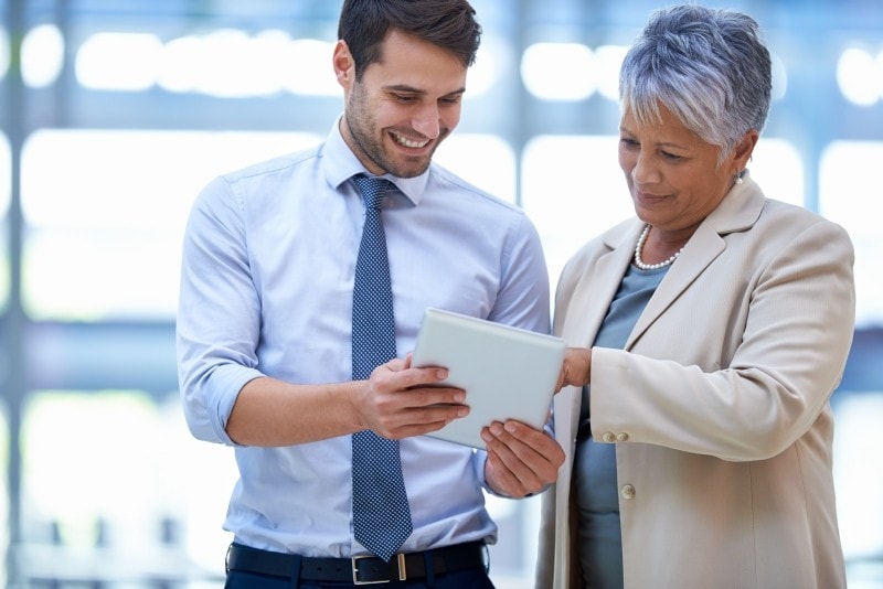 man-and-woman-discuss-work-on-tablet