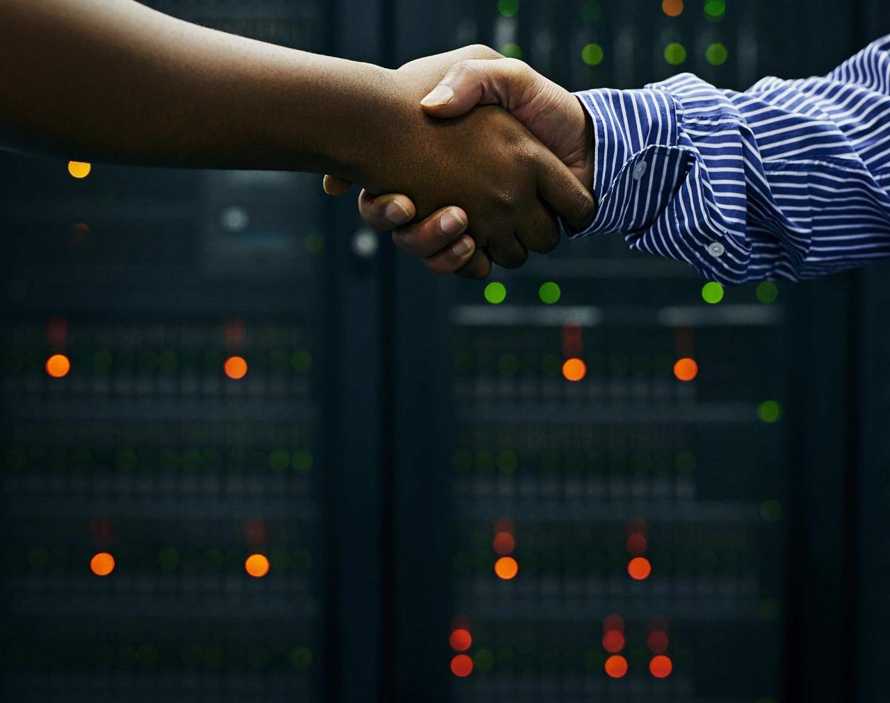 Cropped shot of two men shaking hands in a data center