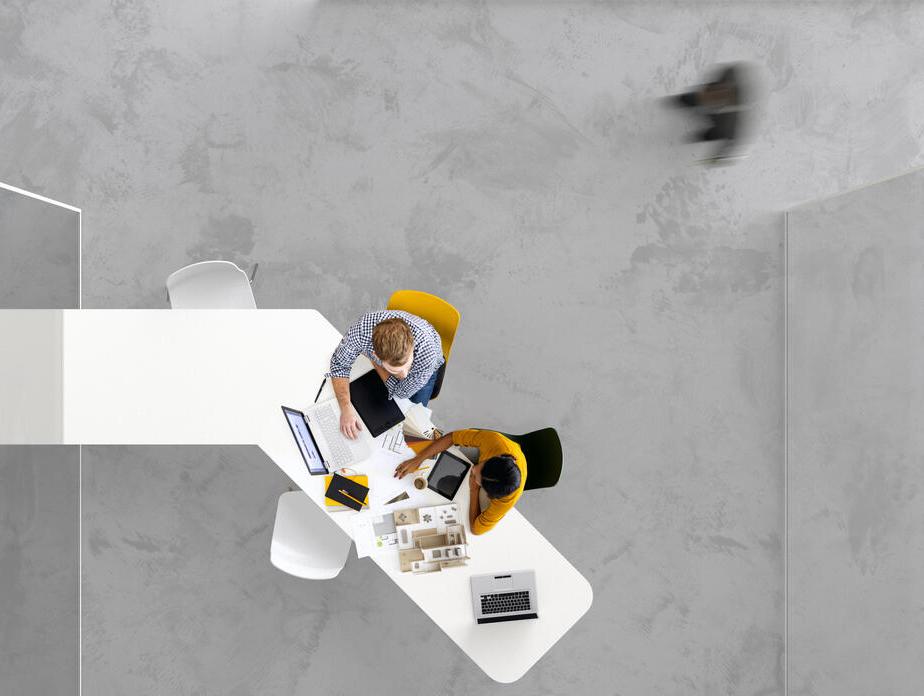 Vogelperspektive auf Menschen, die an einem Schreibtisch arbeiten