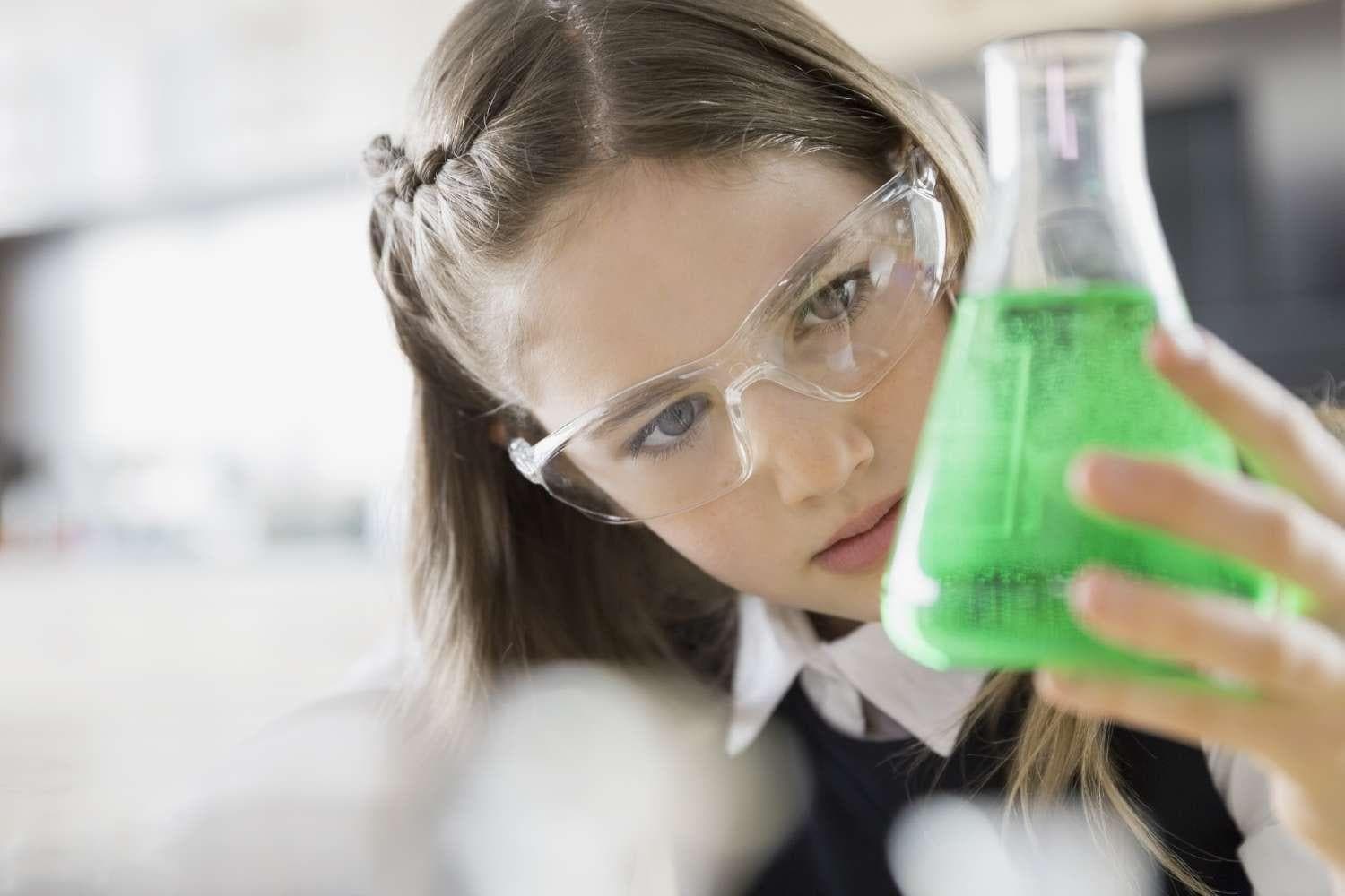 Female student wearing lab glasses and holding lab beaker