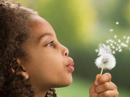 Girl with dandelion making a wish