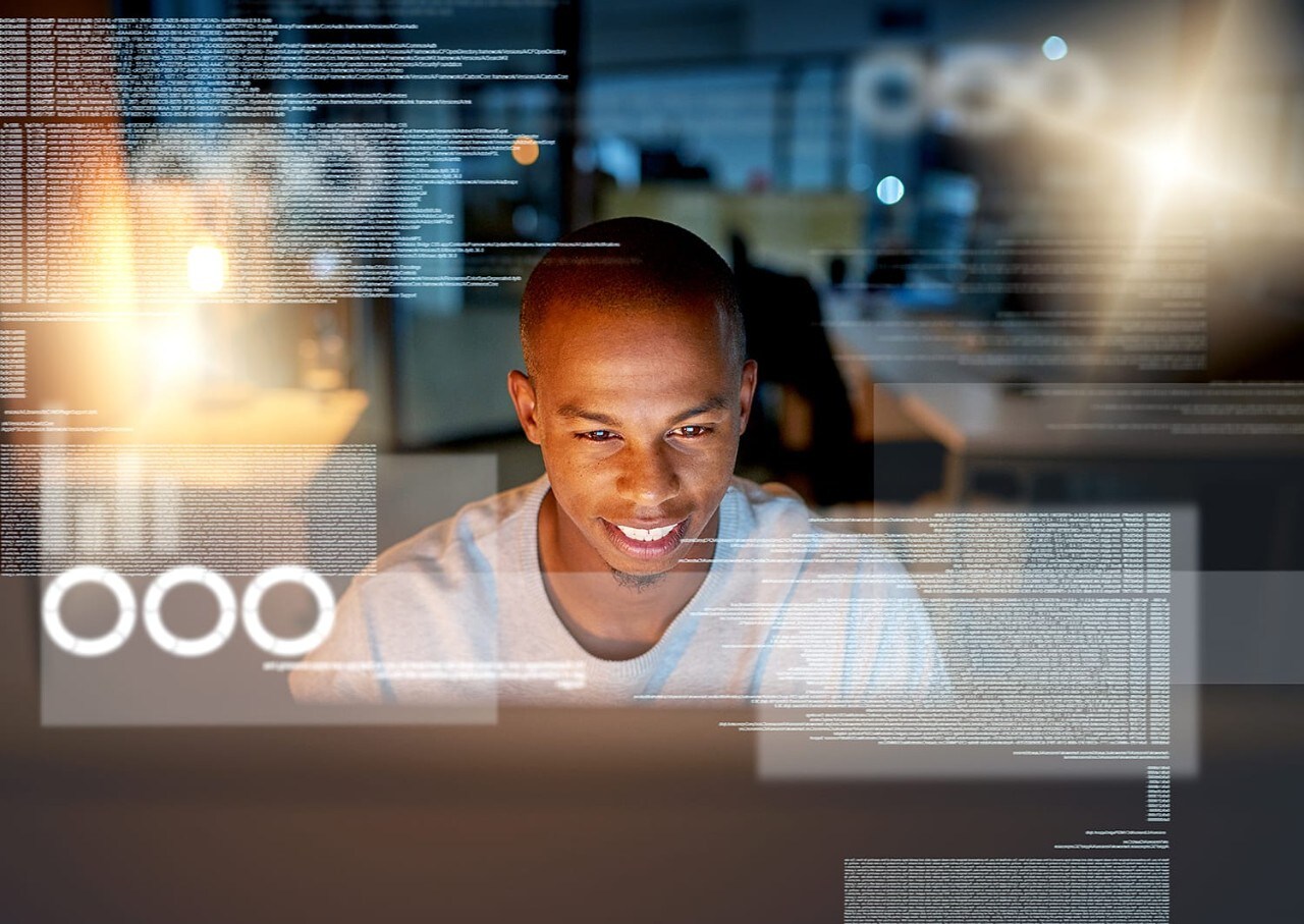 Young male programmer surrounded by virtual code