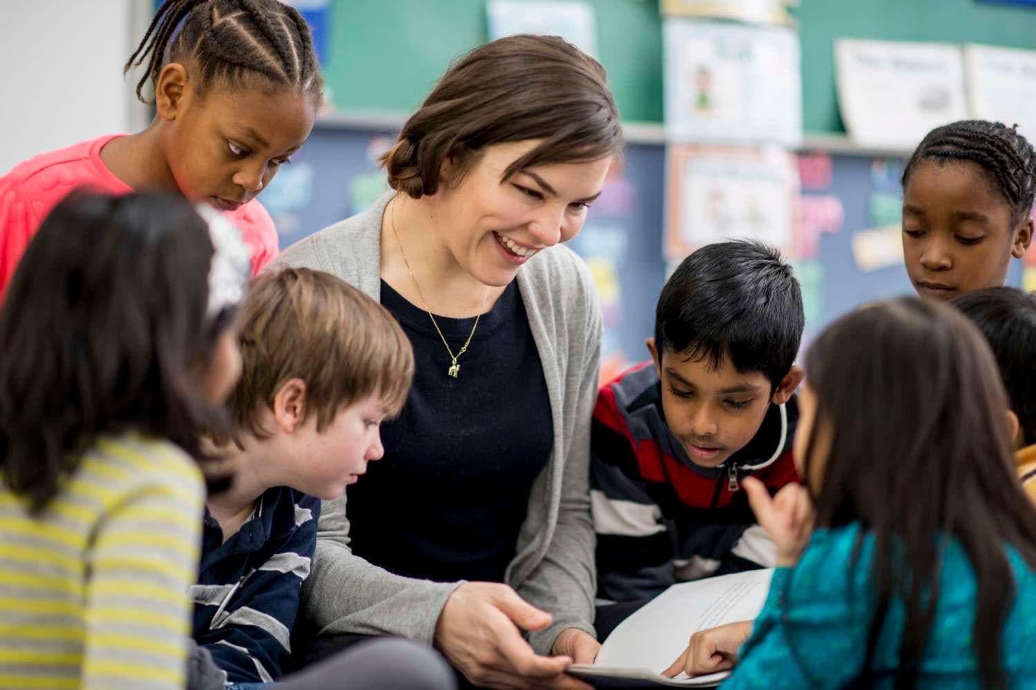 A teacher reads to a diverse group of six elementary school children