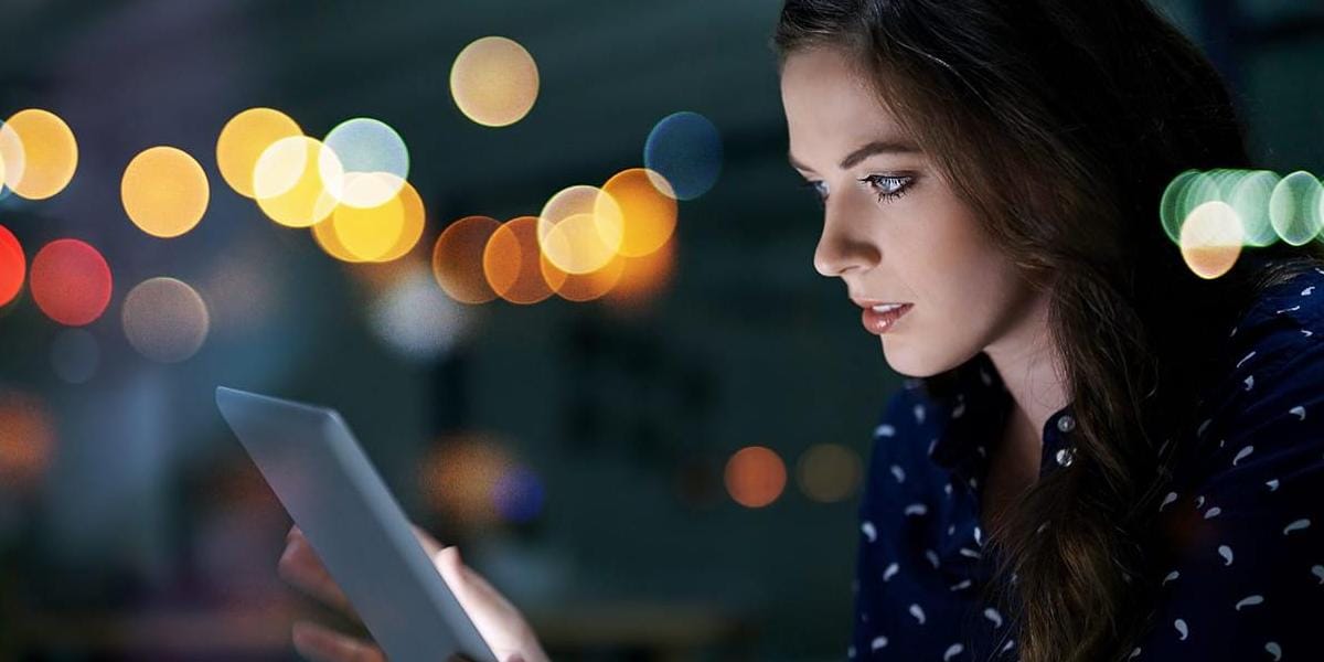 Businesswoman looking at laptop with colorful graphic circles behind her