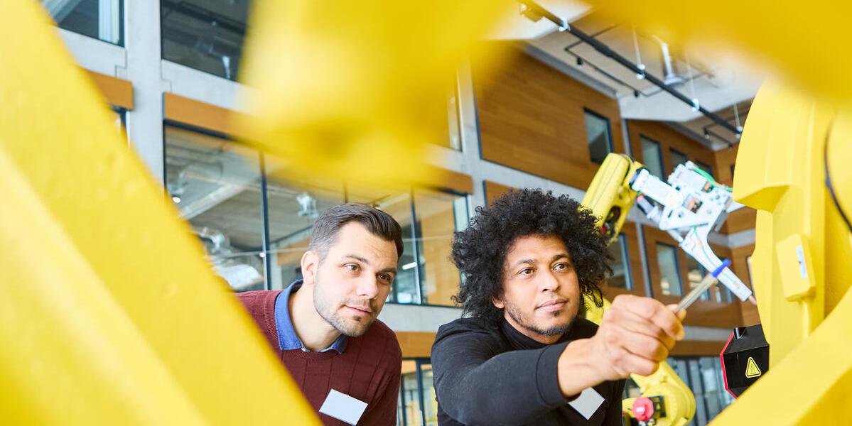 Two engineers working on robotic arm