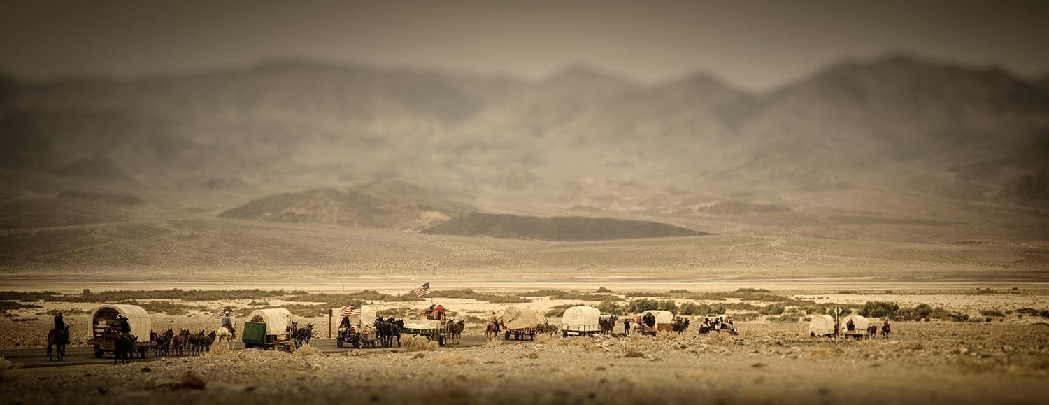 covered wagon train in desert