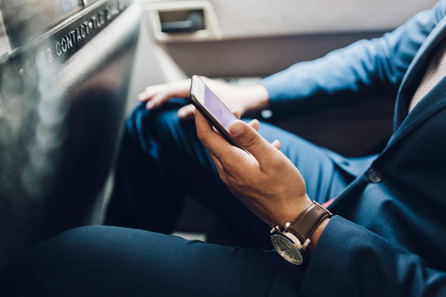 Close up of businessman with mobile phone in taxi