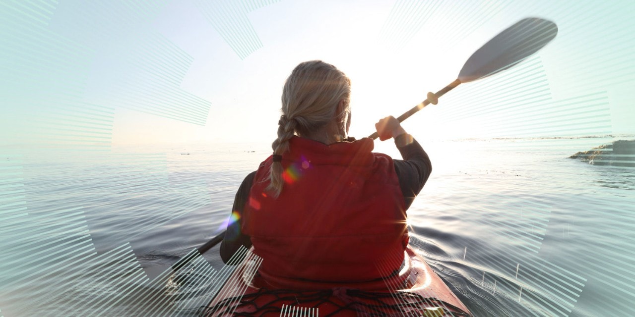 Woman paddles kayak on calm sea, towards sunrise Woman paddles kayak on calm sea, towards sunrise