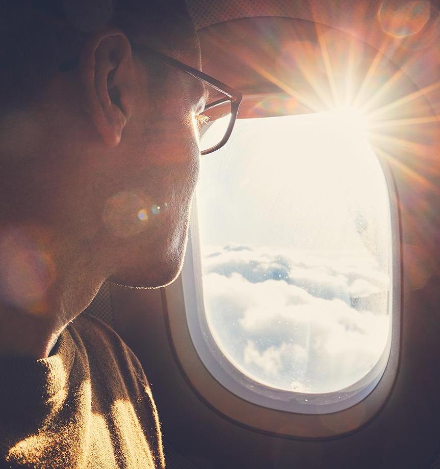 Man on airplane looking out window