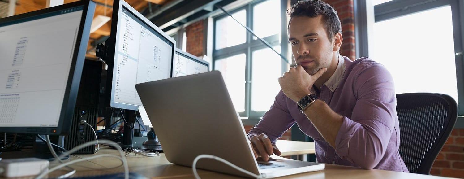 Focused business man working at laptop with SAS® Optimization software