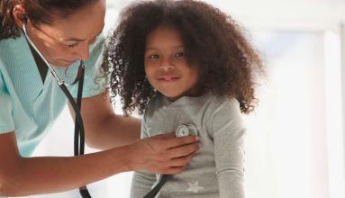 Female Doctor examining a child with stethoscope