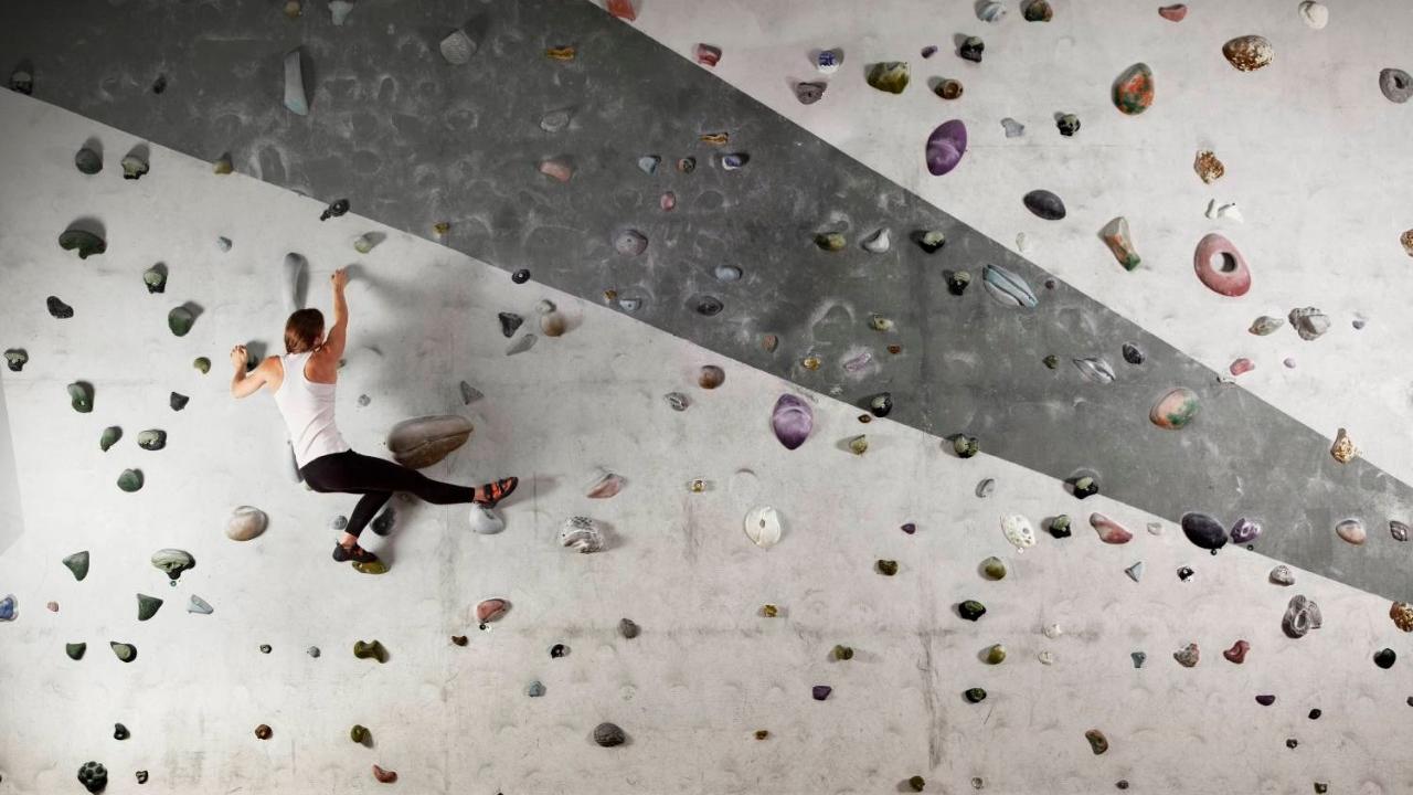 Female climber clinging to indoor climbing wall  