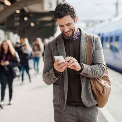 Businessman using mobile phone at train station