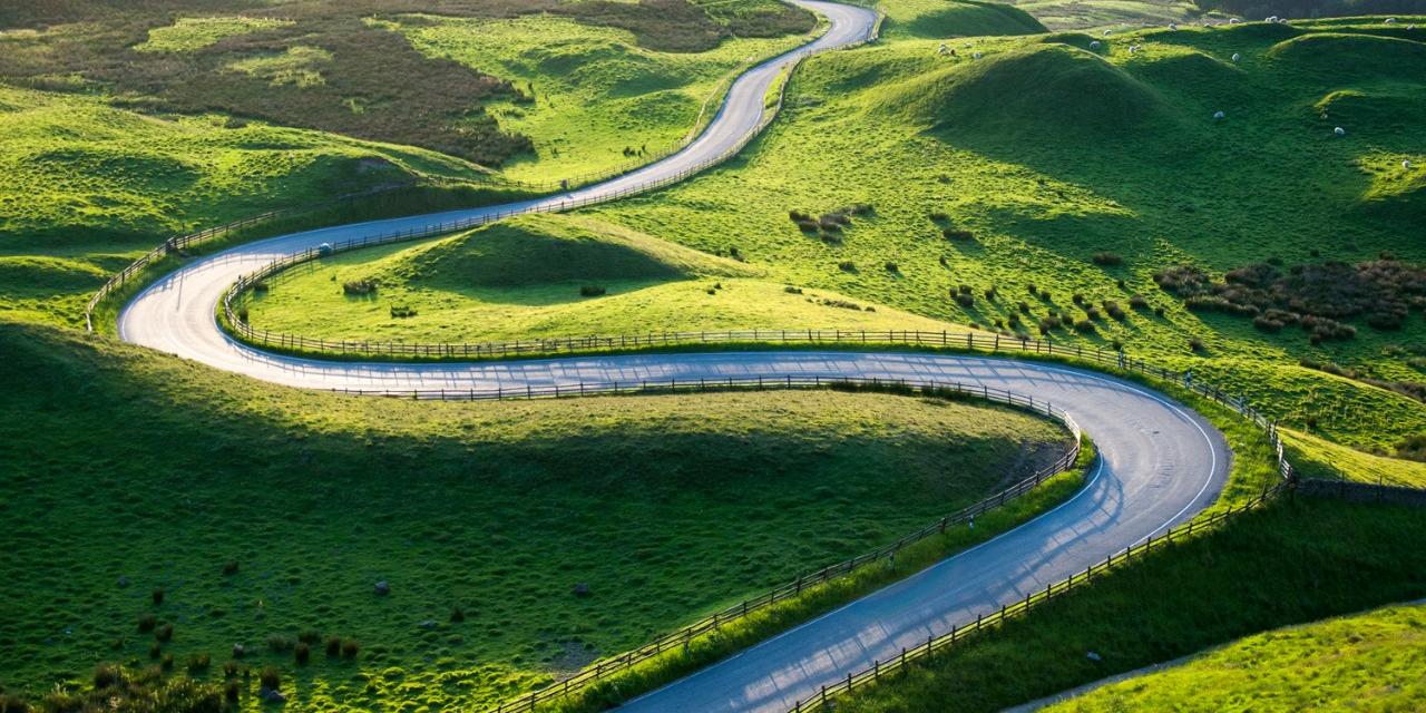 Road bends and weaves in green landscape