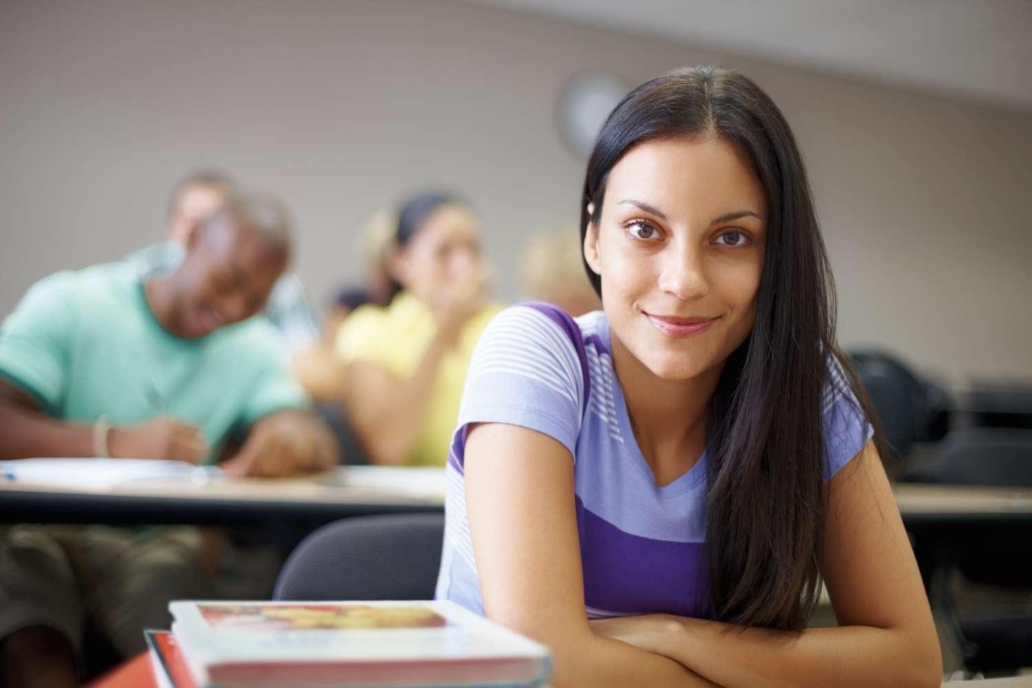 African American college girl sitting in classroom looking at camera.