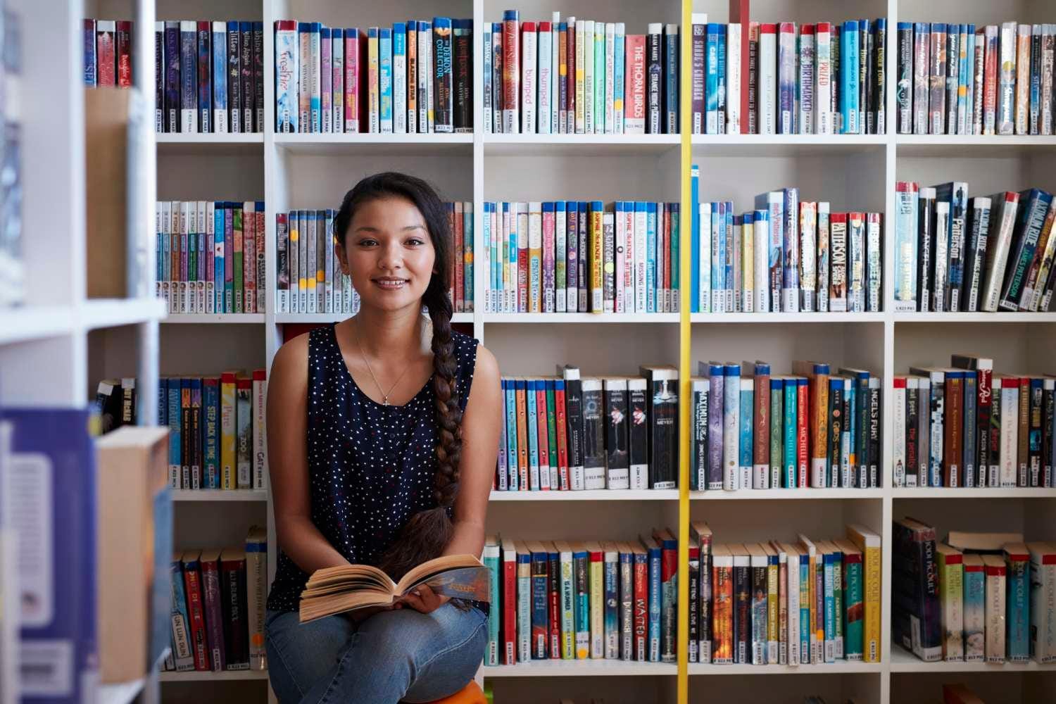 Young girl smiling at camera with an open book