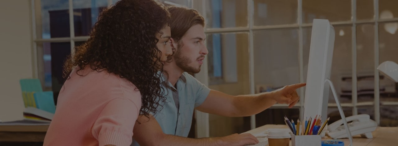 Young man and woman working together at laptop computer