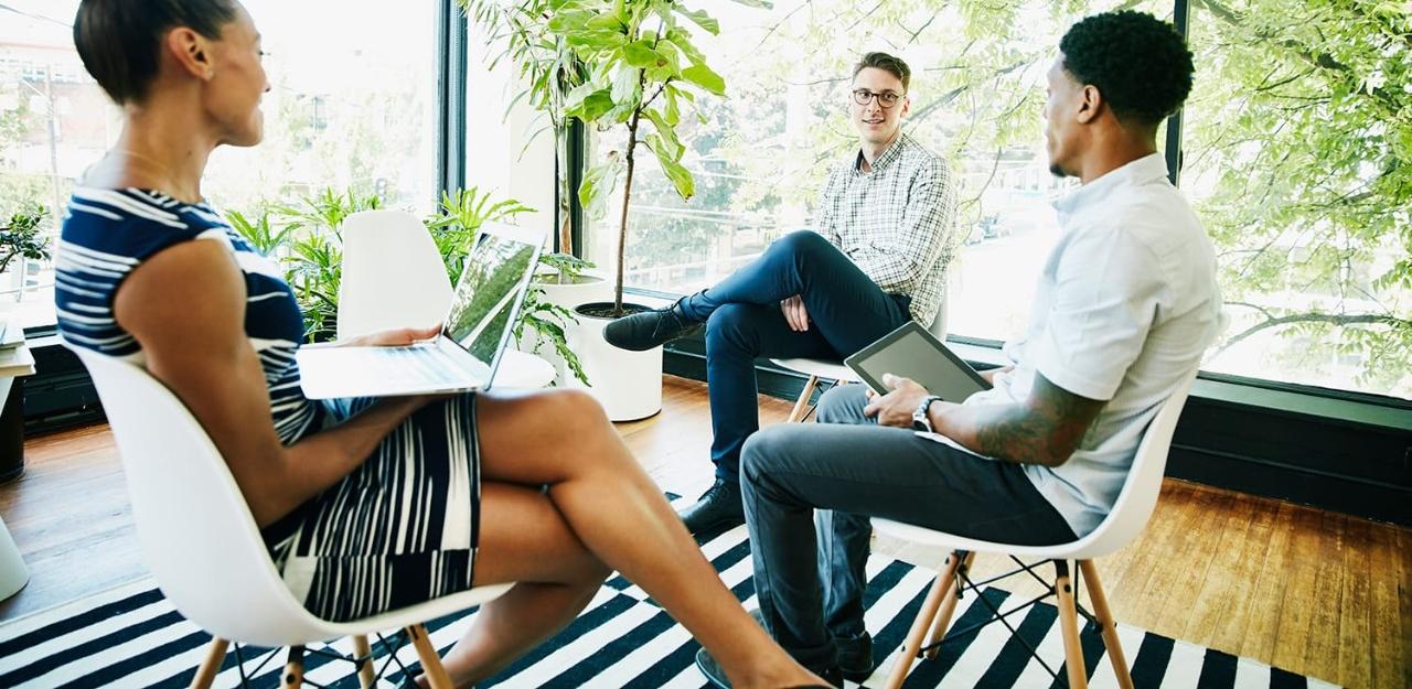 Three coworkers discussing a project in a meeting