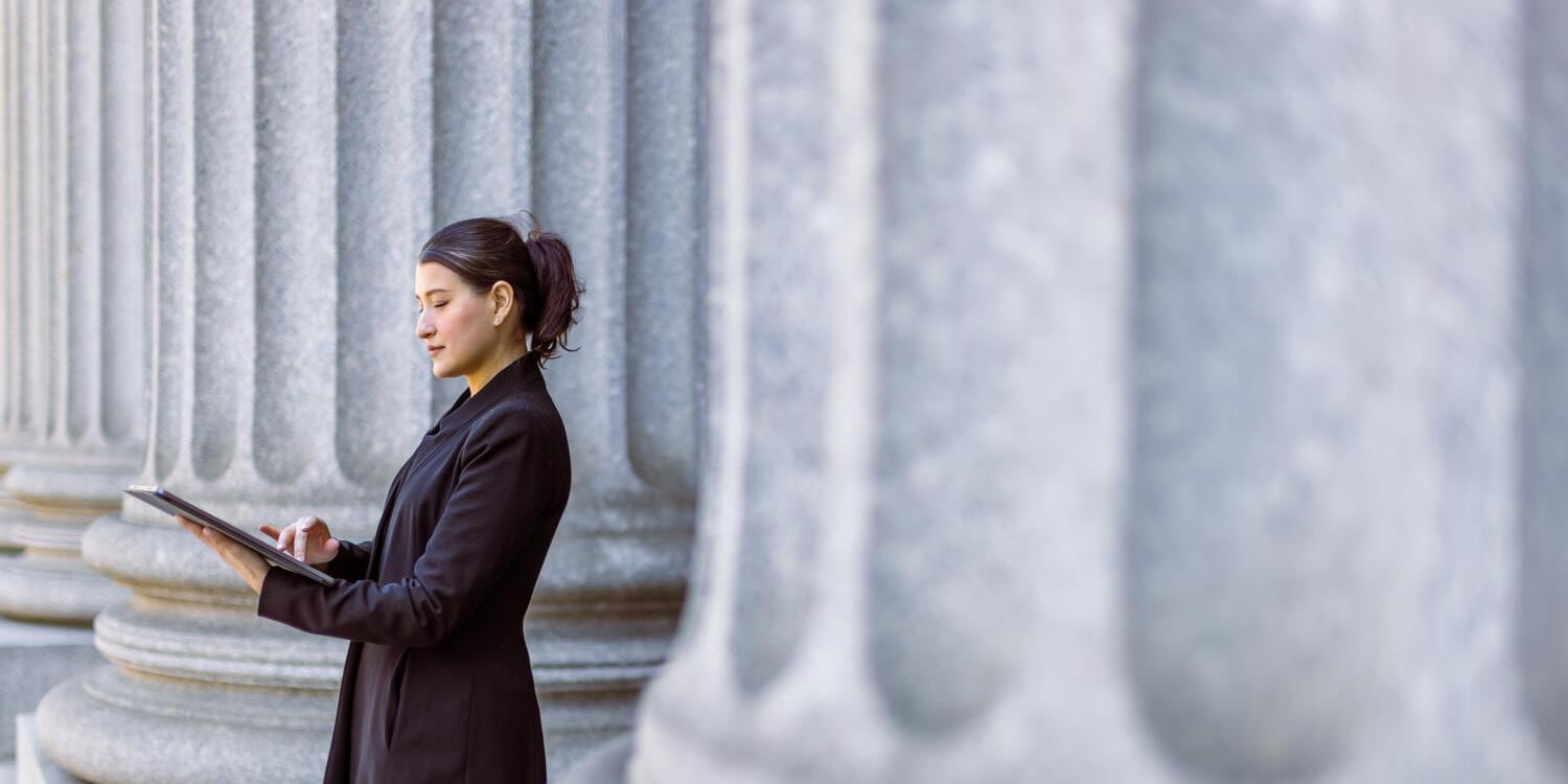Female lawyer using tablet in front of court house