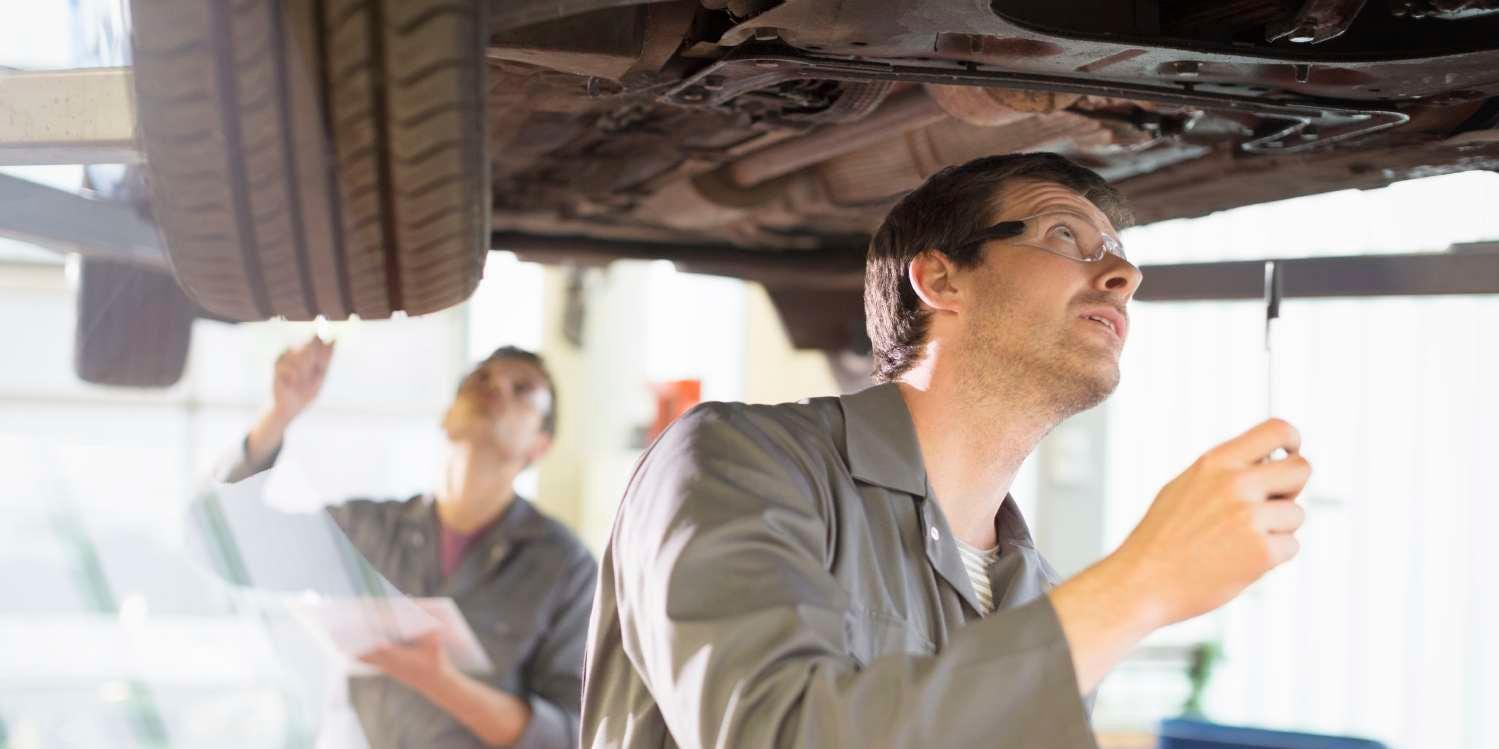 Technician inspecting car