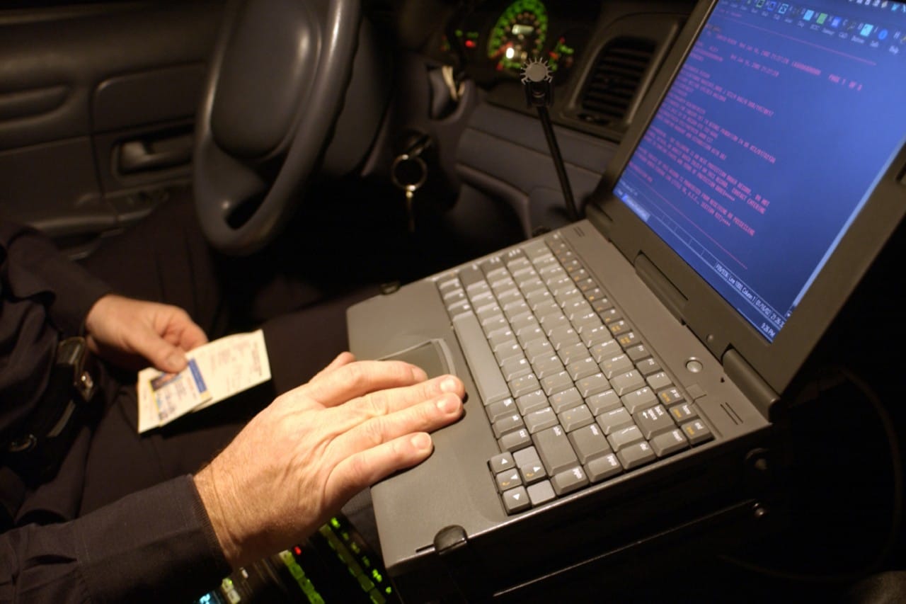 police officer using laptop in patrol car