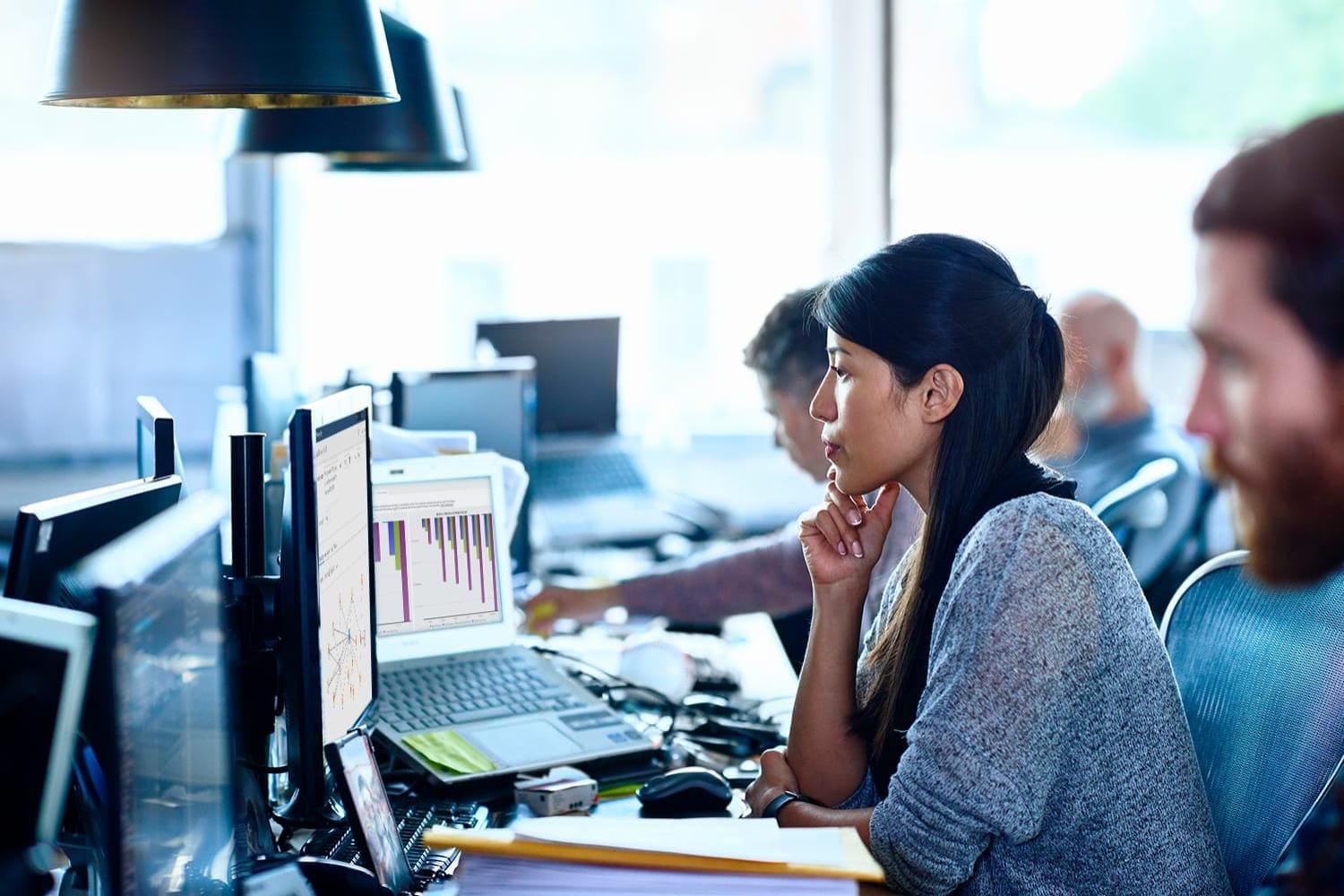 Team of data scientists working at desks in modern office Team of data scientists working at desks in modern office