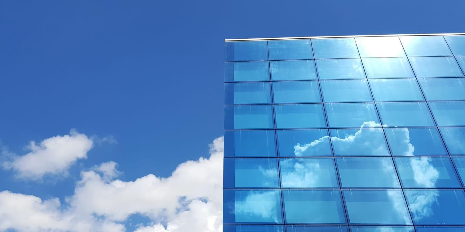 White clouds reflected on building windows
