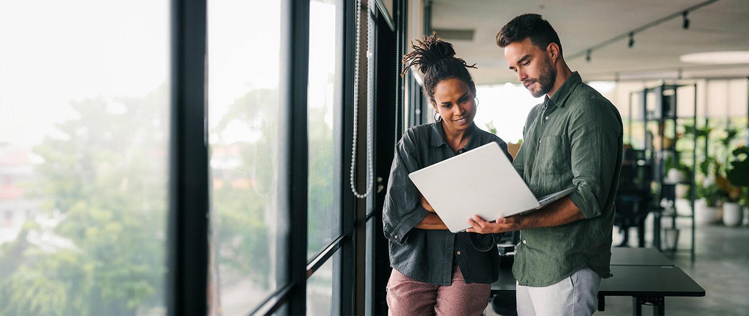 Coworkers looking at a laptop