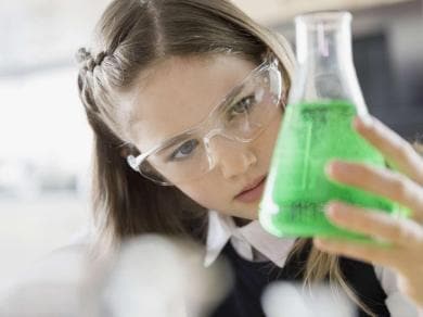 Young scientist holding a beaker with green liquid