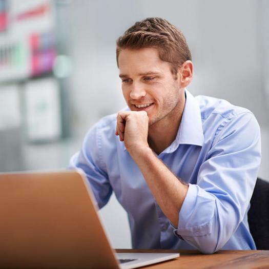 Confident young business man at laptop