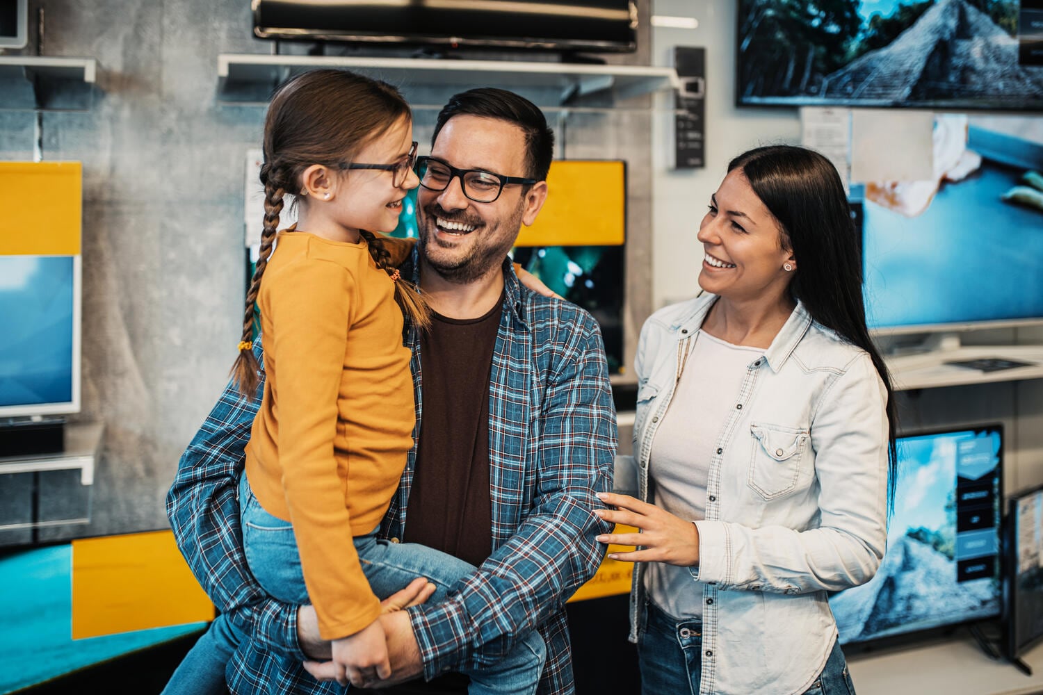 Happy family buying TV in store