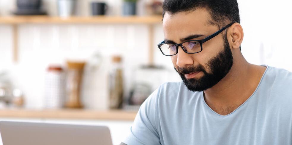 Man sitting at a desk looking at laptop
