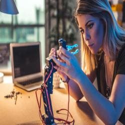 Young woman working in a robotics workshop