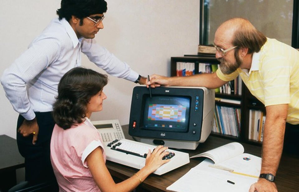 SAS employees using an old IBM computer in the 1970s