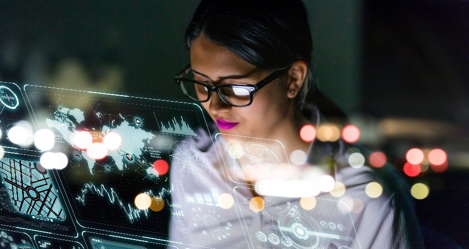 Business woman with glasses looking at a screen reflecting data