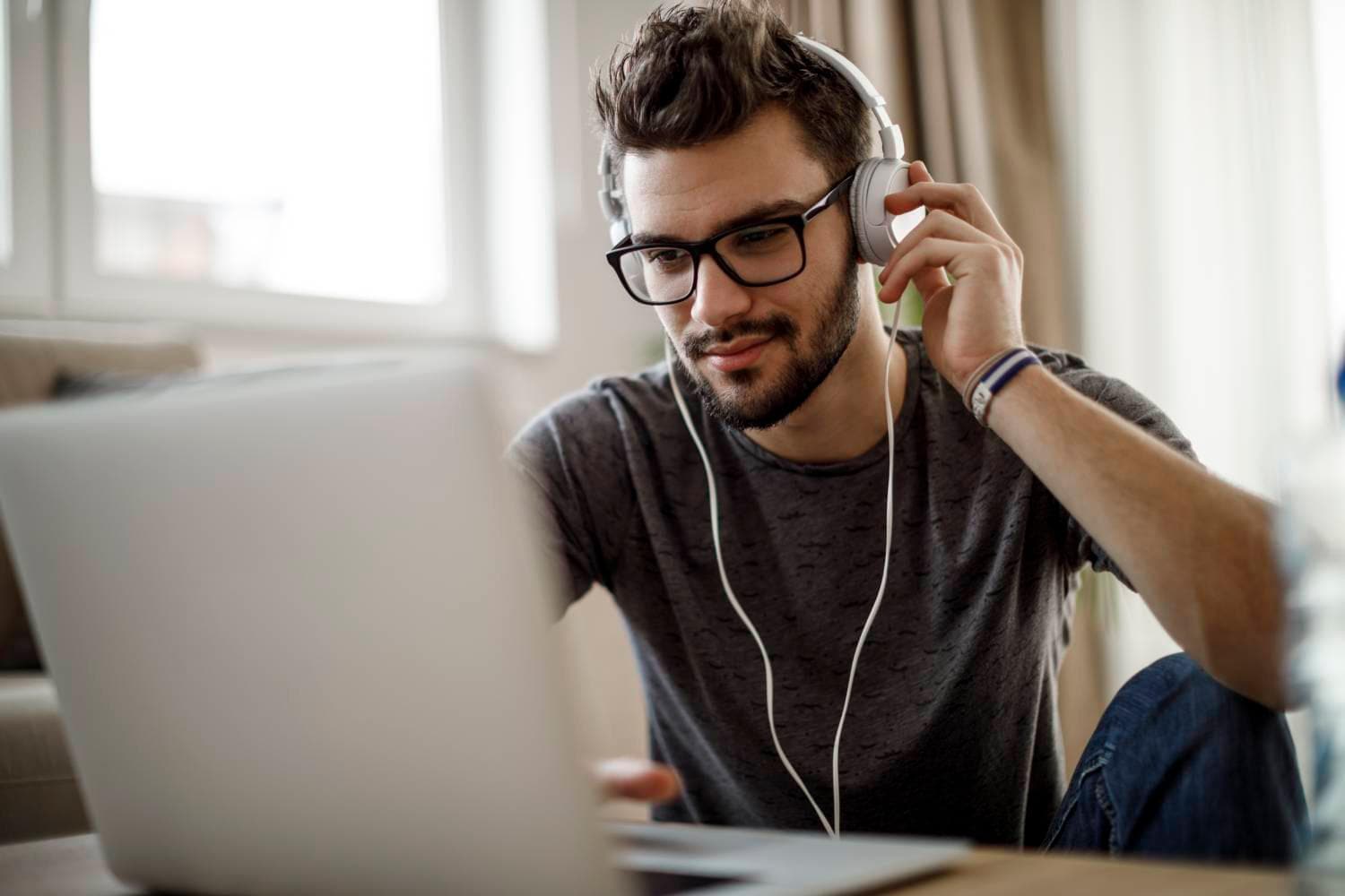 Man wearing headphones looking at a laptop
