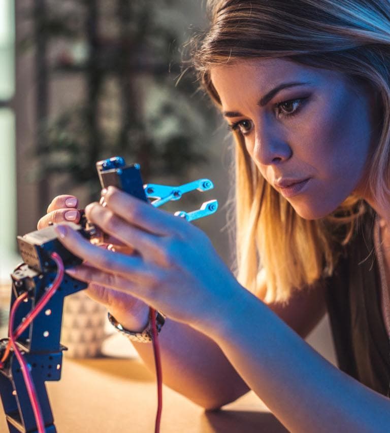 Young woman building a robot