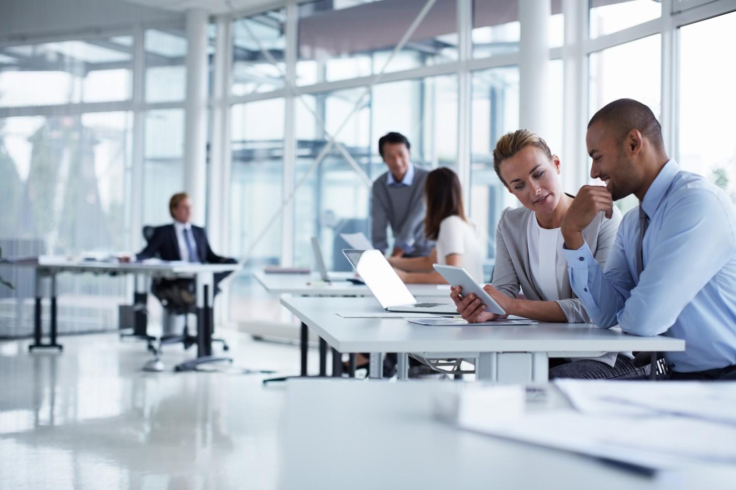 Business colleagues discussing over digital table at office desk