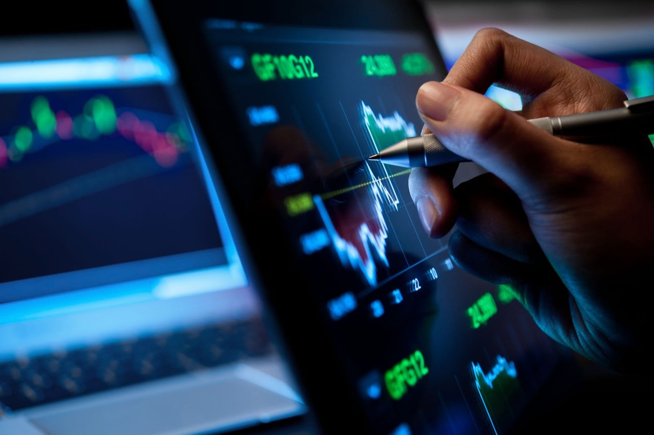 Person writing on tablet with charts