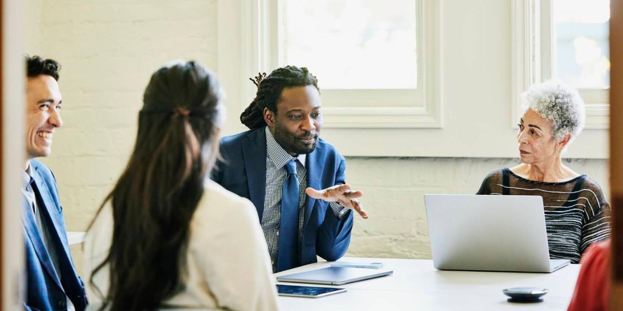 Purpose and Commitments Businessman leading team meeting in conference room
