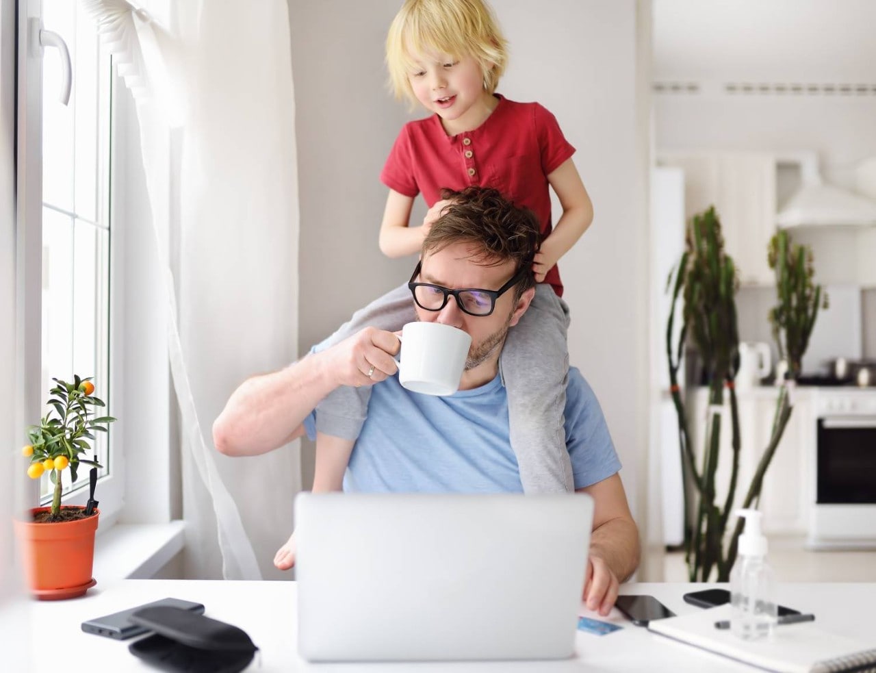 Man and child working from home with laptop