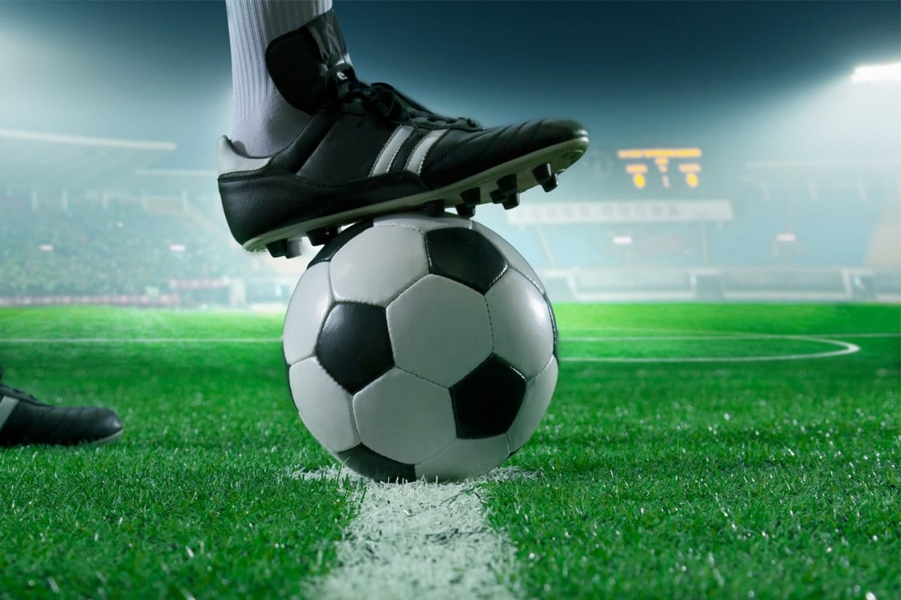 Foot on soccer ball in stadium Foot on soccer ball in stadium